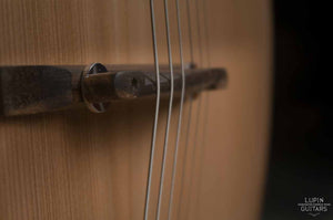 Steel string compensated bridge